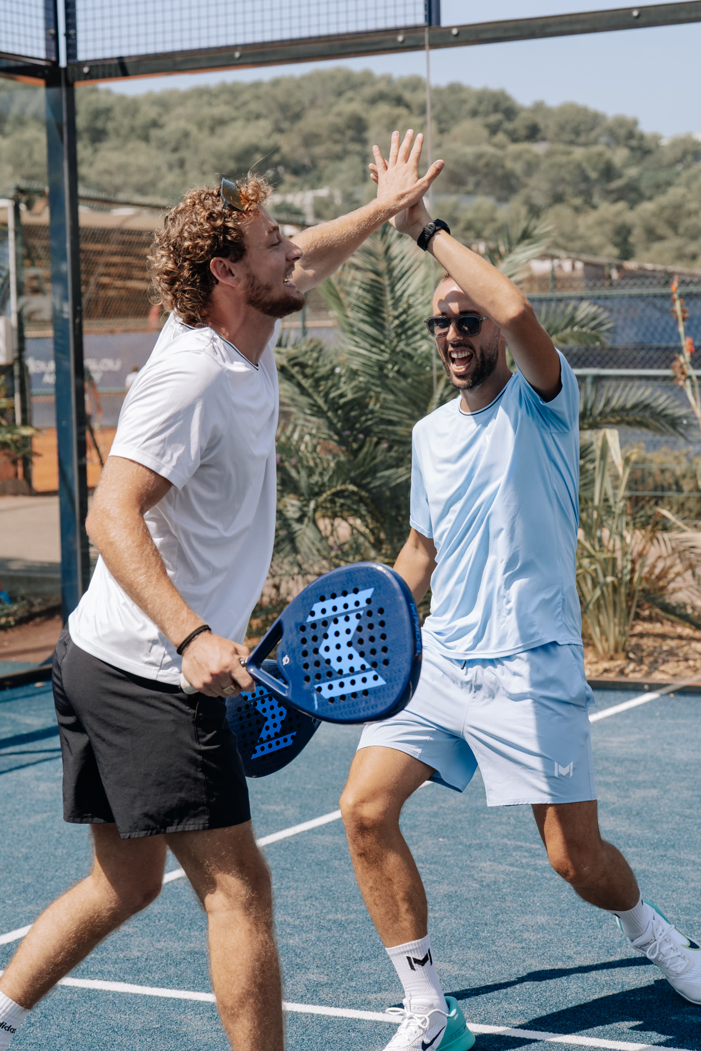 Deux joueurs de padel célèbrent un point au Mouratoglou Country Club